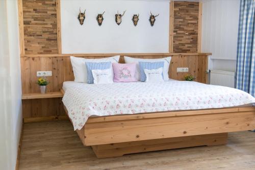 グンツェスリートにあるLandhaus Waibelhofのベッドルーム1室(ピンクとブルーの枕が備わる木製ベッド1台付)