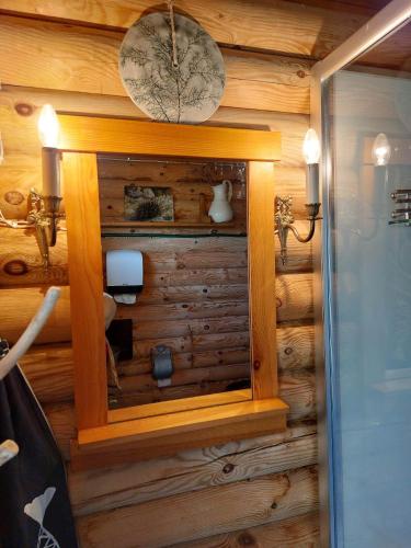 a bathroom with a wooden wall with a mirror at Ohessaare mereäärne camping in Ohessaare