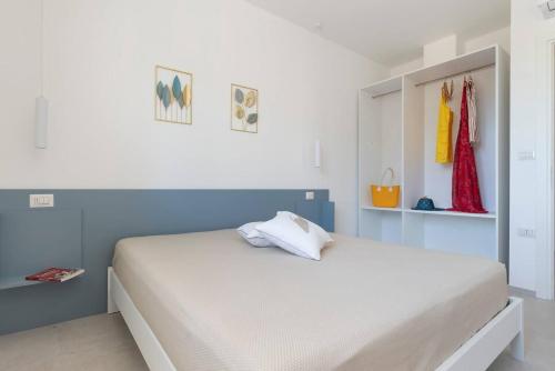 a bedroom with a large white bed with blue walls at Le Secche Suite & House 1 by Salento Prime in Torre Pali 