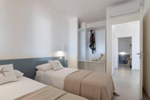 a bedroom with two beds and a hallway at Le Secche Suite & House 2 by Salento Prime in Torre Pali 