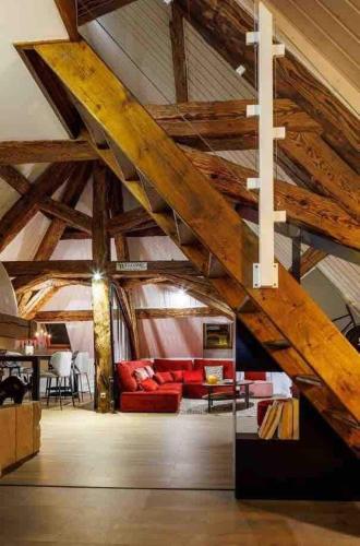 Elle comprend un salon doté de plafonds en bois et d'un canapé rouge. dans l'établissement Spacious apartment in the heart of the city center, à Lons-le-Saunier