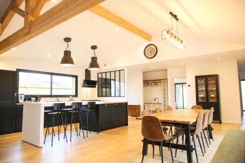 une cuisine et une salle à manger avec une table et des chaises en bois dans l'établissement Villa Onébien, à Gujan-Mestras