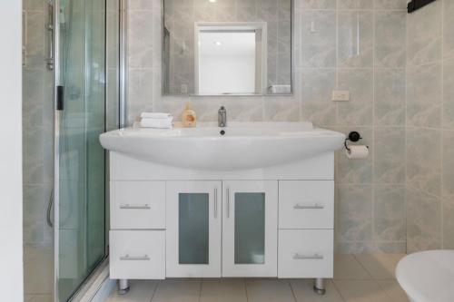a bathroom with a white sink and a shower at Affordable 1Bed Studio Close to Malls and Transit in Brisbane