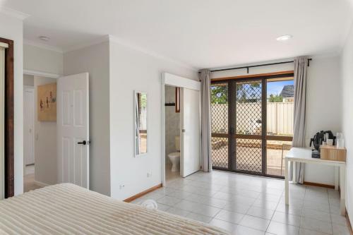 a white bedroom with a bed and a balcony at Affordable 1Bed Studio Close to Malls and Transit in Brisbane
