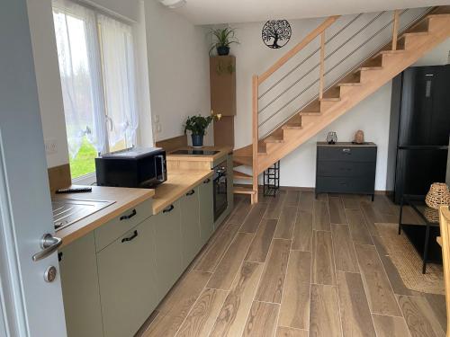 Il comprend une cuisine avec du parquet et un escalier. dans l'établissement Duplex l Auvetia 150 m circuit 24 h, à Arnage
