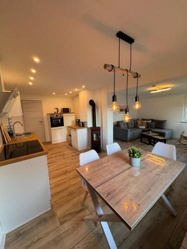 a kitchen and a living room with a wooden table at NEU! Ferienhaus am Sonnenlandpark - Haus Anja in Lichtenau