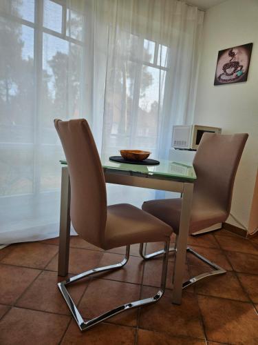 a table with two chairs and a microwave at Seeblick III in Bad Saarow