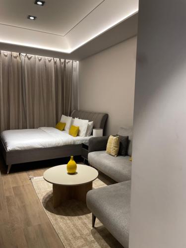 a living room with a couch and a table at The City Landing Apartments At The Diamond in City in Accra