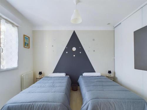 3 lits dans une chambre avec un mur pyramidal dans l'établissement Bourg d'Olonne sur Mer, charmante maison pour 6, à Les Sables-dʼOlonne