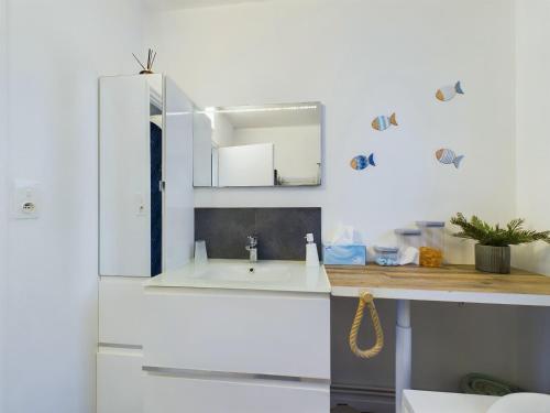 - une cuisine blanche avec un évier et un miroir dans l'établissement Bourg d'Olonne sur Mer, charmante maison pour 6, à Les Sables-dʼOlonne