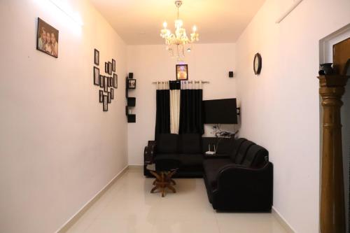 a living room with two chairs and a chandelier at Bougainvillea Homestay in Nedukandam