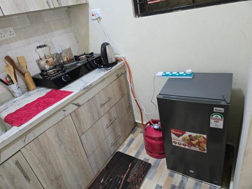 a small kitchen with a sink and a refrigerator at Maliar Homes in Voi