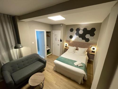 a hotel room with a bed and a couch at Hotel Monasterio Granada - Adults Only in Granada