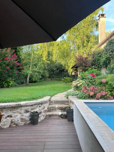 a backyard with a swimming pool and a garden at Maison Charmille in Féricy