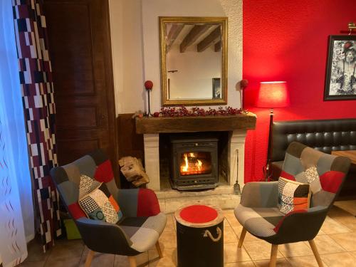 a living room with a fireplace and chairs and a mirror at Logis Auberge De Launay in Limeray
