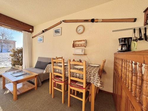 un salon avec une table, des chaises et un canapé dans l'établissement Studio ski-in/ski-out à Notre-Dame-de-Bellecombe, piscine, tennis, parking - 4 personnes - FR-1-595-3, à Notre-Dame-de-Bellecombe