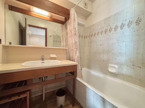 une salle de bain avec un lavabo et une baignoire dans l'établissement Studio ski-in/ski-out à Notre-Dame-de-Bellecombe, piscine, tennis, parking - 4 personnes - FR-1-595-3, à Notre-Dame-de-Bellecombe