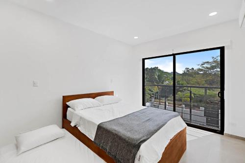 una camera bianca con un letto e una grande finestra di Casa Corales Dreams Deluxe a Playa Flamingo