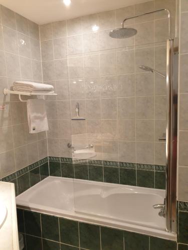 un bagno con vasca e doccia in vetro di le Mas des Cigales a Tourrettes-sur-Loup