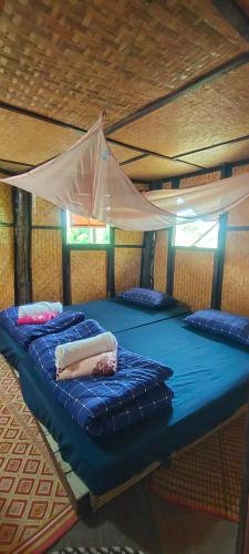 two beds in a room with a tent at Baan 2 Dao Farmstay in Chiang Dao