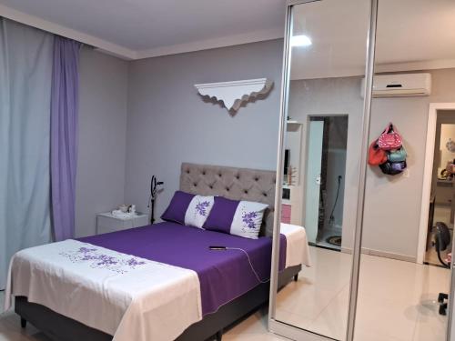 a bedroom with a purple bed and a mirror at Doce Lar- COP 30 in Ananindeua