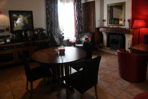 a dining room with a table and chairs and a fireplace at Logis Auberge De Launay in Limeray