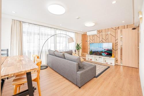 a living room with a couch and a flat screen tv at 鵜の木民宿202号室鵜の木駅から徒歩4分とても便利の場所 in Tokyo