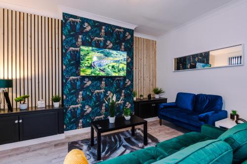 a living room with a blue couch and a blue chair at Beautiful Home In Bolton in Bolton