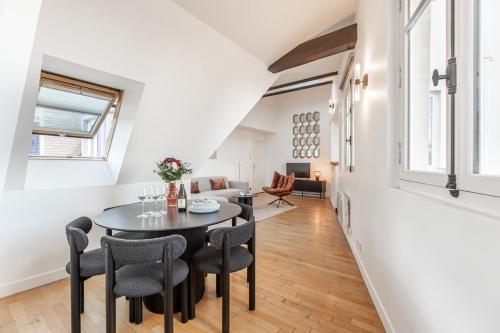 une salle à manger et un salon avec une table et des chaises dans l'établissement Amazing Apartment 3Bedrooms Champs Elysées AC, à Paris