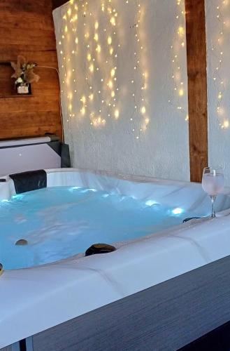 a bath tub with a wine glass sitting on a bed at HIŽA BAKE ROZE in Gornja Konjšćina