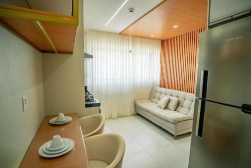 a kitchen with a couch and a table and a refrigerator at Gaudium Apart-Hotel in João Pessoa