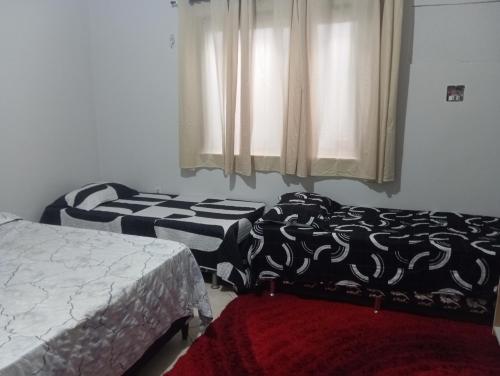 a bedroom with two beds and a window at Apartamento mobiliado no centro, Siqueira Campos, in Santarém