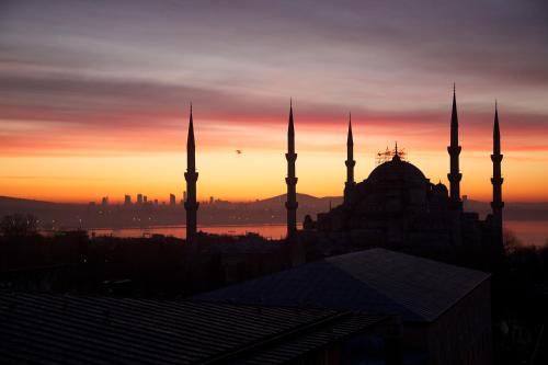 una silueta de una mezquita con una puesta de sol en el fondo en Lady Diana Hotel en Estambul