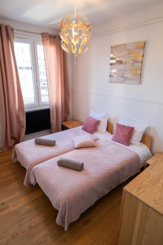 - 2 lits dans une chambre dotée d'un lustre dans l'établissement Le Mandallaz - Coeur d 'Annecy, à Annecy