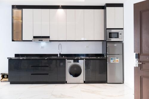 a kitchen with a washing machine and a microwave at فندق الماسة للأجنحة الفندقية in Tripoli