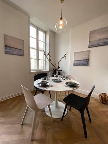 une salle à manger blanche avec une table et des chaises blanches dans l'établissement Magnifique Appartement Vieux Port Refait à Neuf, à La Rochelle