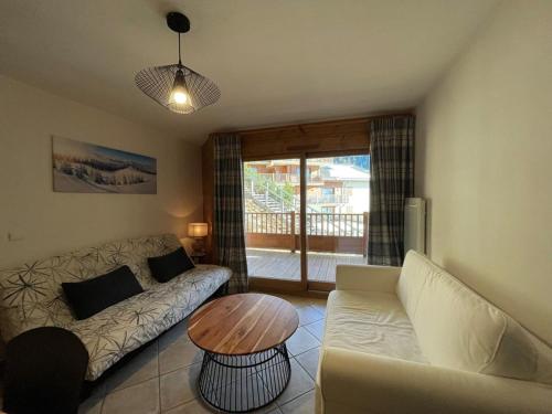 un salon avec un canapé et une table dans l'établissement Appartement familial 6 pers. avec piscine, balcon et parking à Crest-Voland - FR-1-733-127, à Crest-Voland