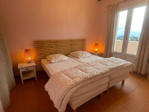 une chambre avec un grand lit et deux lampes dans l'établissement Villa à Cavalaire-sur-Mer avec piscine, sauna, parking et animaux acceptés - FR-1-226B-156, à Cavalaire-sur-Mer