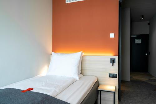 a bed in a room with an orange wall at Citybox Antwerp in Antwerp