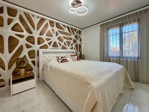 - une chambre dotée d'un lit blanc avec un mur en bois dans l'établissement Villa Zénith - Piscine chauffée & Paillotte Bambou, à Nîmes