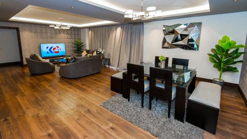 a living room with a table and chairs and a television at The Expert in Ocean Blue Near Airport in Cairo