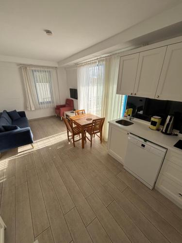 a kitchen and a living room with a table and chairs at Carpediem Apart in Kas