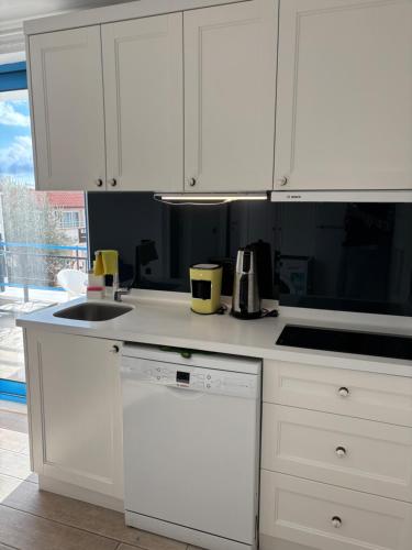 a white kitchen with a sink and a dishwasher at Carpediem Apart in Kas