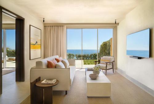a living room with a couch and a large window at Fairmont La Hacienda Costa del Sol in Alcaidesa