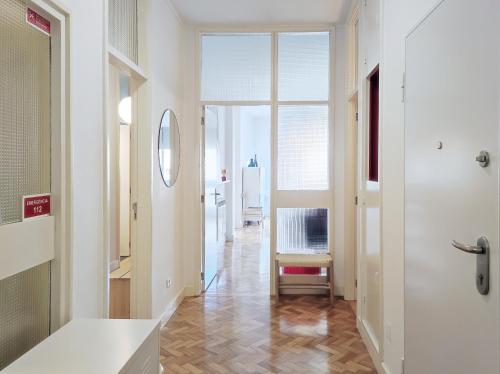 a hallway with white walls and wooden floors and a door at E36 - ideal for families - large areas in Porto