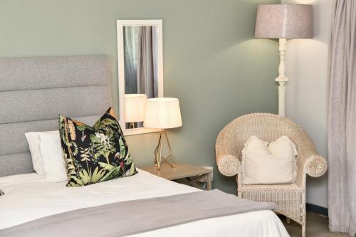a bedroom with a bed and a chair and a mirror at Gowan Valley Guest Farm in Balgowan