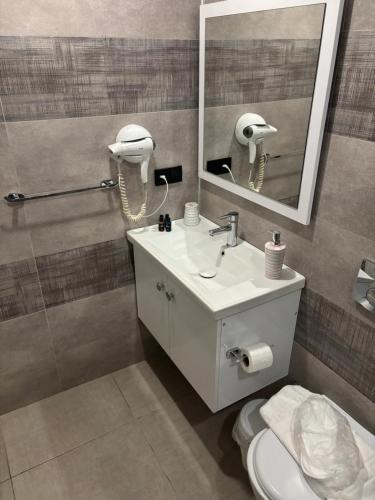 a bathroom with a sink and a mirror and a toilet at Carpediem Apart in Kas