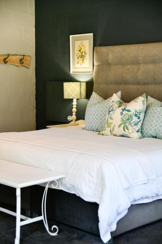 a bedroom with a large bed with white sheets and pillows at Gowan Valley Guest Farm in Balgowan