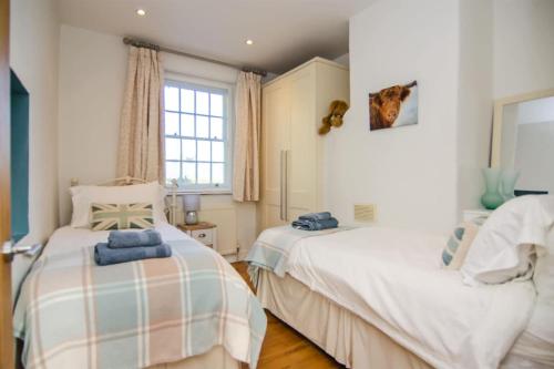 a bedroom with two beds and a window at Pudding Cottage in Bakewell in Bakewell