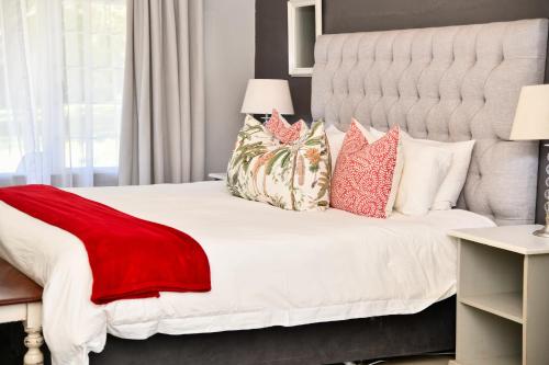 a bedroom with a large white bed with pillows at Gowan Valley Guest Farm in Balgowan